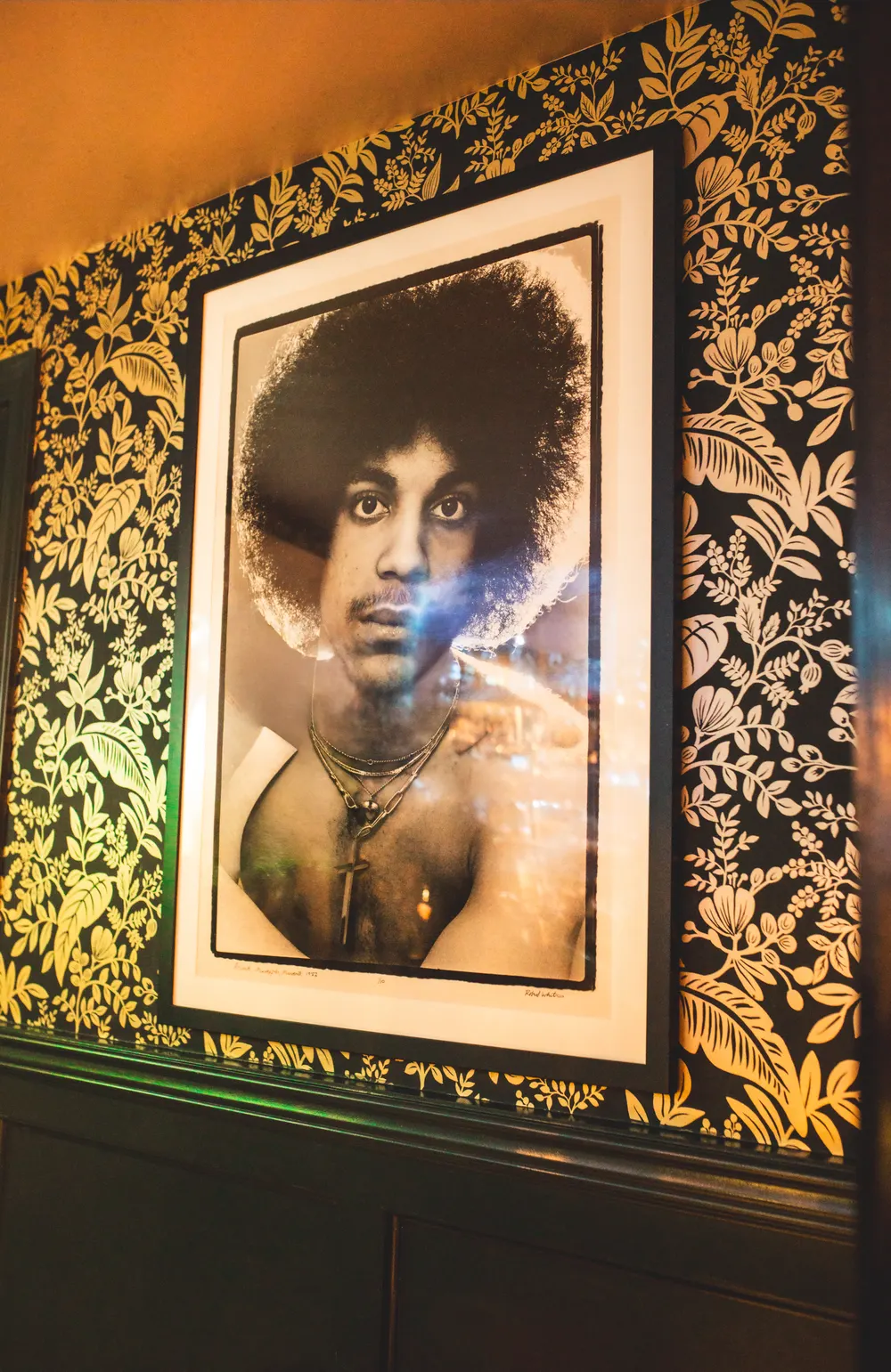 Framed portrait art on ASA's gilded wallpaper